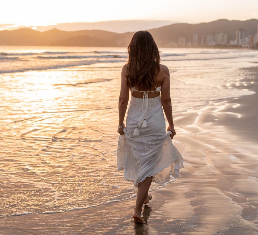 woman walking by the sea - mindfylness walking, slow living tips.