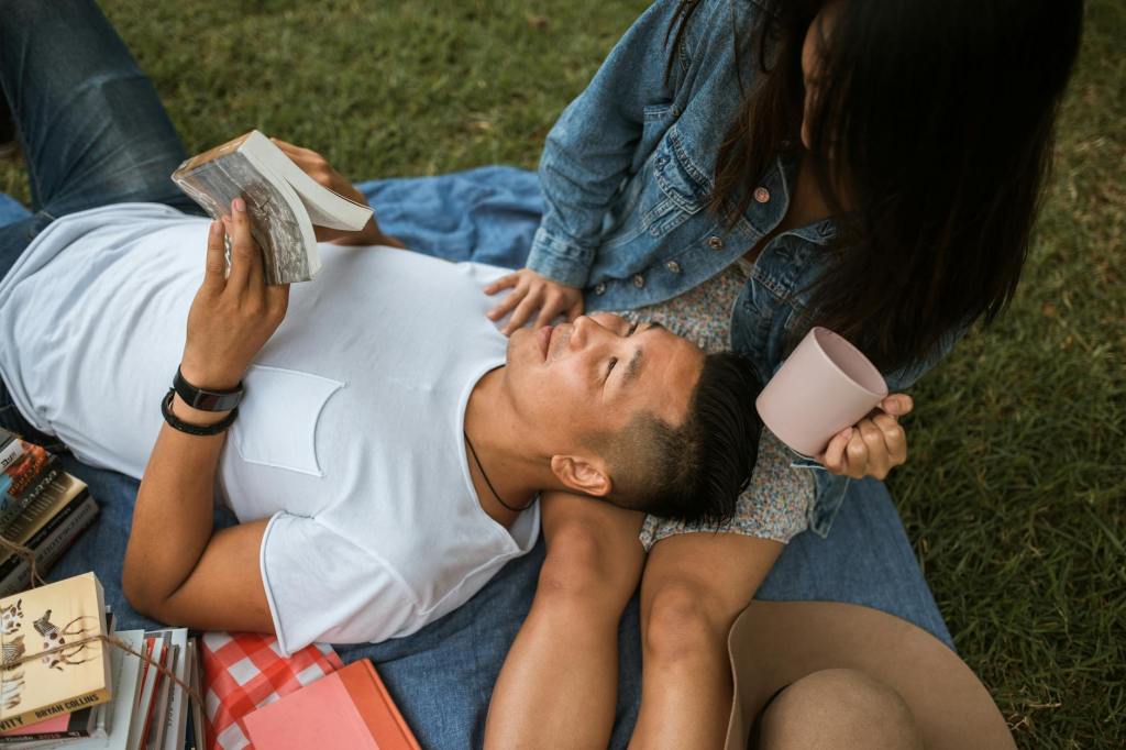 A couple relaxing outdoors on a blanket, reading slow living books and enjoying calm moments